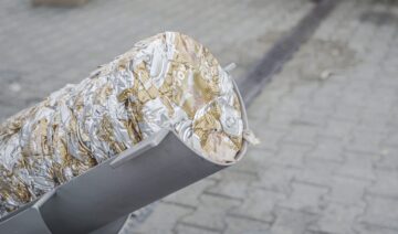 Verpresste 500 ml Bierdosen werden aus dem Auswurf geschoben
