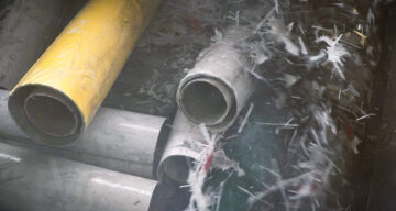 Rohre mit Glasfaser werden auf dem drehenden Rotor geshreddert