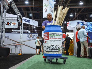 Freeman worker collects wood waste on the tradeshow floor
