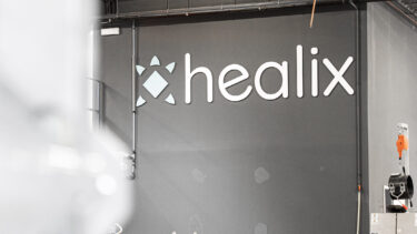 Logo der Firma Healix auf einer Wand in der Produktionshalle in Maastricht