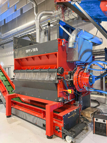 Orangener WEIMA Shredder mit Hydraulikantrieb bei Healix in Produktionshalle