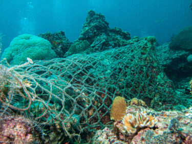 Ozen Plastik Müll Ghost Nets auf Grund neben Korallen