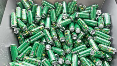 grüne oettinger bierdosen in einem edelstahl container