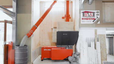 orangener WEIMA WL 4 shredder vor einer holzwand mit förderschnecken