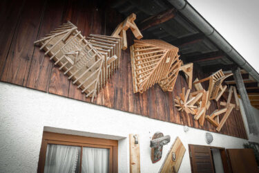 Konstruktionen aus Holzbalken hängen an einer Hausfassade