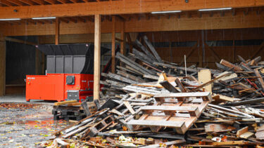 WEIMA Shredder neben Haufen aus Altholz