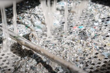 water dripping down on metal collection bin underneath puehler press