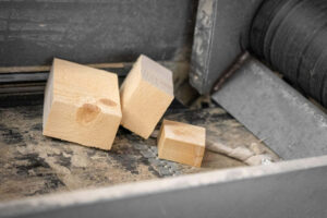 Ein Förderband beladen mit 3 Holzstücken