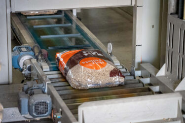 ein einzelner Holzpellets Sack liegt auf einem Förderband