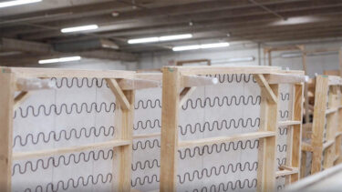 Unfinished wood beds stand on their sides in a warehouse.