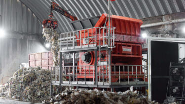 WEIMA PreCut 2500 shreds pulper waste from paper recycling, loaded via crane