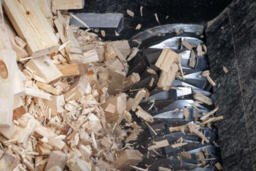 Ein Rotor zerkleinert die Holzblöcke und Holzreste.