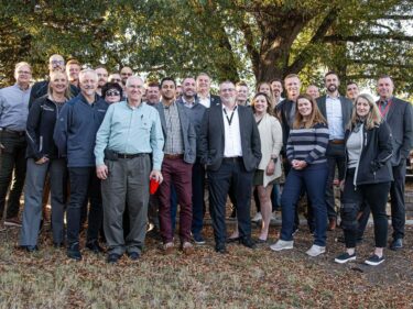 The Sustainability & Recycling Committee poses with some WEIMA employees for a group photo in the beer garden.