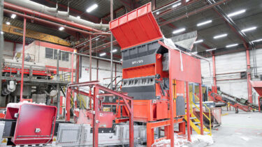 An orange WEIMA W5.18 single-shaft shredder shreds LDPE film at RKW in Hoogstraten, Belgium