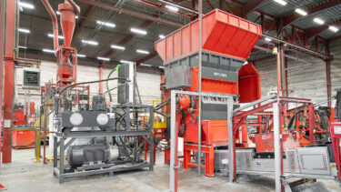 Ein orange-roter Shredder mit hydraulischem Antrieb