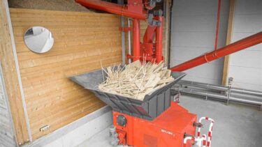 Mit Holzabfällen befüllter WEIMA WLK 1500 Shredder neben einem Spänebunker