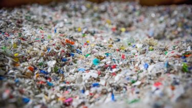 Mit WEIMA Shredder zerkleinerte bunte Kunstoff Flakes in einem Behälter