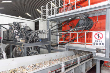 Austragsförderband mit zerkleinerten Müll, darüber ein Hydraulikantrieb von Hägglunds