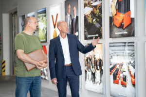 Kay Schulte at the WEIMA headquarters in front of photos on a white wall