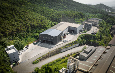 An industrial hall in South Korea with a forest in the background