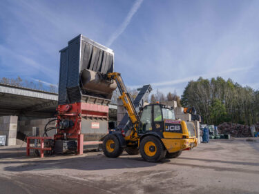 An excavator fills the WEIMA Shredder PowerLine 2500