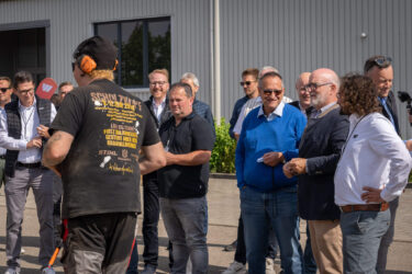Mehrere Menschen stehen um Leute rum die Skulpturen sägen