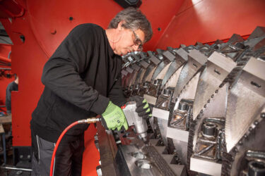 WEIMA service technician readjusts the blades on a shredder.