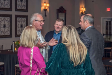 A large group of people talking at a party