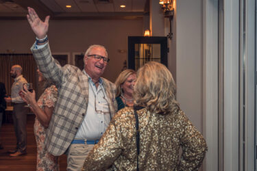 Two people greet each other warmly at the party