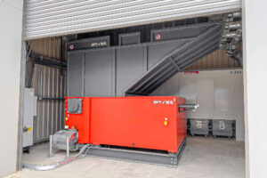 a orange WEIMA WL20 shredder in a small hall, with an dust extractor behind