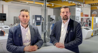 zwei baumüller mitarbeiter stehen an einem pult im baumüller technikum