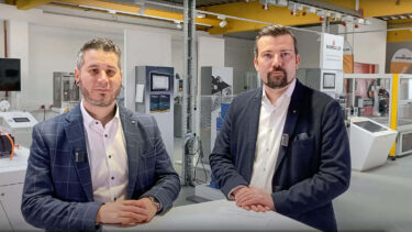 Two Baumüller employees standing at a desk for a Desch High-Torque Webinar