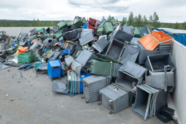 Ein Berg von alten Mülltonnen auf einem Recyclinghof