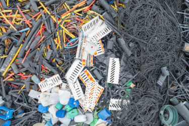 Luftaufnahme von einem Berg an Harkunststoff Abfällen auf einer Recycling Anlage