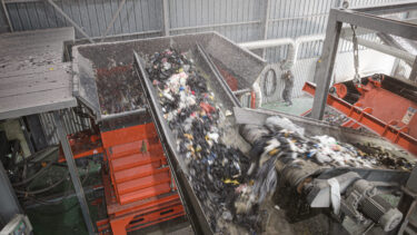 WEIMA PreCut 3000 shredder at Tosung for shredding textile waste using a fully loaded conveyor belt