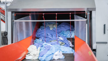 Textiles on a conveyor belt before shredding