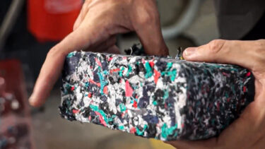 A briquette made from shredded textiles, held in the hands