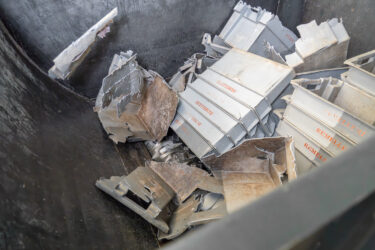 Gestapelte graue Kunststoffboxen im Shredder