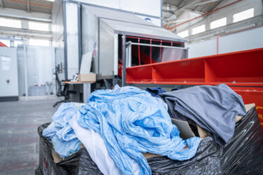Textilien Abfälle für das Recycling vor einem Förderband