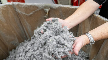 Shredded nonwoven padding held up by a member of staff