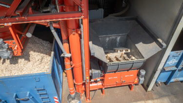 Blick von oben auf den WEIMA WLK 1500 Einwellen-Zerkleinerer mit Förderschnecke von Steiner und Container